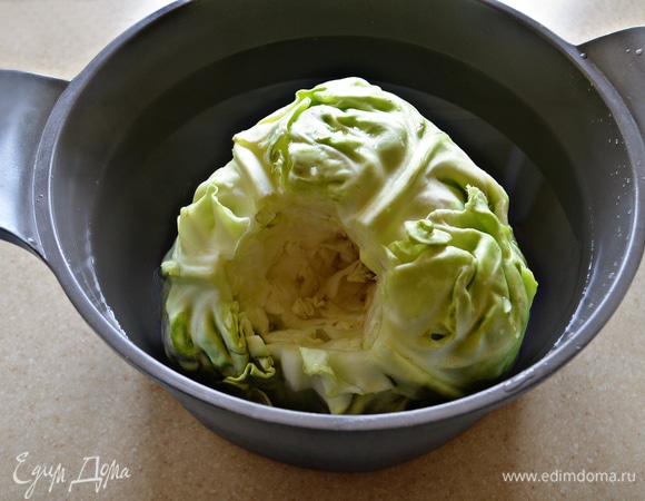 Небольшой кочан капусты промойте, очистите от внешних подпорченных листьев, вырежьте кочерыжку. Поместите капусту в большую кастрюлю, залейте горячей подсоленной водой и варите 10–15 мин. После варки выньте кочан из кастрюли, остудите. Листья будут легко отделяться от основания.
