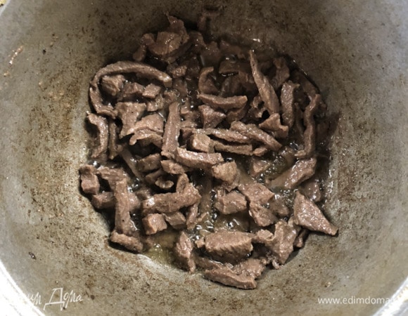 В кастрюлю (казан, вок) добавляем утиный жир, топим, шкварки достаем, обжариваем говядину, постоянно помешивая.