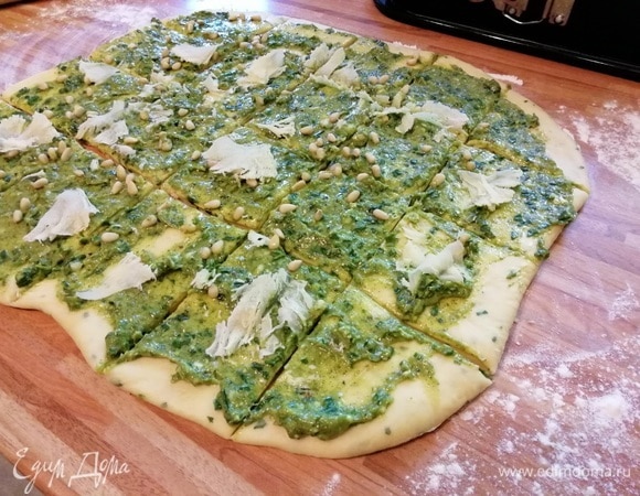 Посыпать орешками и тертым сыром. Сыр подойдет любой, в том числе и фета. Разрезать острым ножом на крупные квадраты.