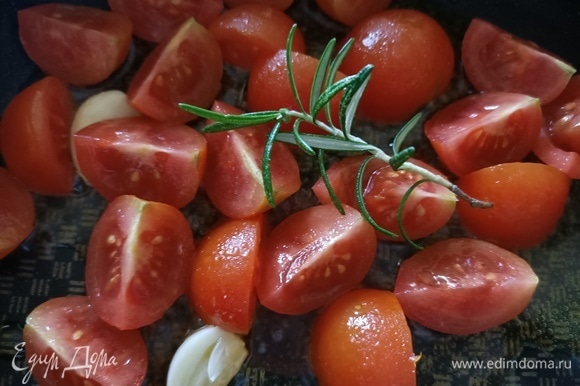 В сковороду добавить оливковое масло, зубчик чеснока, помидоры и розмарин. Готовить 3–4 минуты.