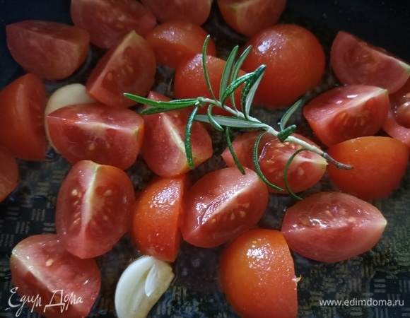 В сковороду добавить оливковое масло, зубчик чеснока, помидоры и розмарин. Готовить 3–4 минуты.