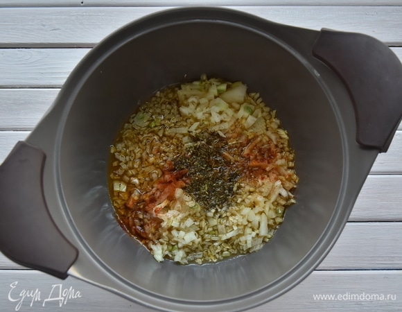 В кастрюлю влить оливковое масло и пассеровать мелко нарезанные лук и чеснок. Когда лук станет мягким и прозрачным, всыпать приправы.