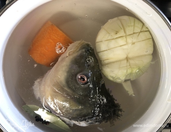 Для первого бульона у меня была голова карпа. Заливаем ее холодной водой, добавляем целую луковицу, морковь, лавровый лист, перец горошком, доводим до кипения, снимаем пенку, немного убавляем огонь, варим 40 минут.