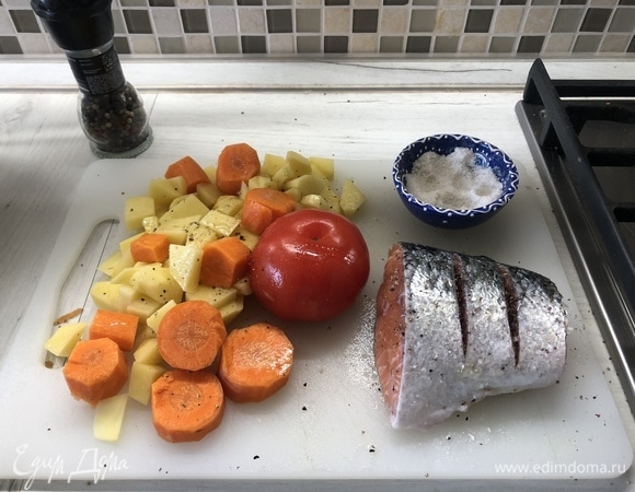 Крупно режем картофель, морковь, делаем надрезы на лососе и помидоре, сбрызгиваем маслом, солим, перчим.