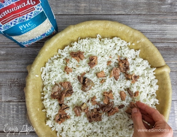 Выкладываем слой риса. У тунца я убрала косточки и поломала его на крупные кусочки. Кладем его на слой риса и поливаем бульоном от тунца (я добавила примерно 5 ст. л.).