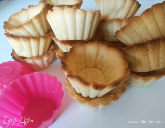 Раскатать тесто толщиной 2–3 мм. Вырезать кружки, выложить их в формочки для маффинов. Дно наколоть вилкой. Выпекать корзинки 15–20 минут (в статической духовке — при 180°C, в духовке с вентилятором — при 170°С).