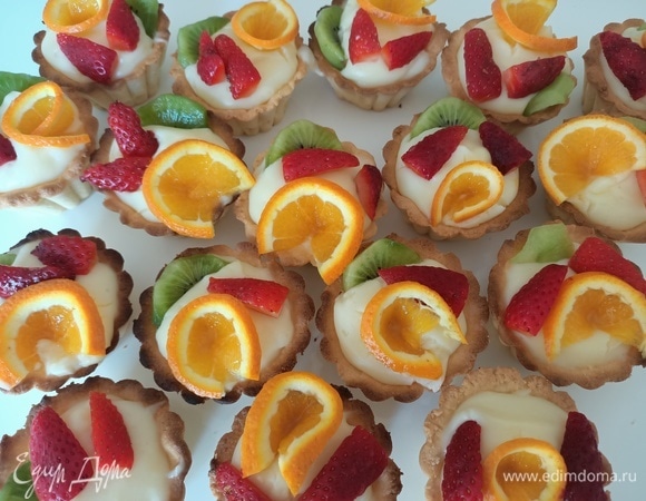 Корзинки наполнить заварным кремом, украсить фруктами.