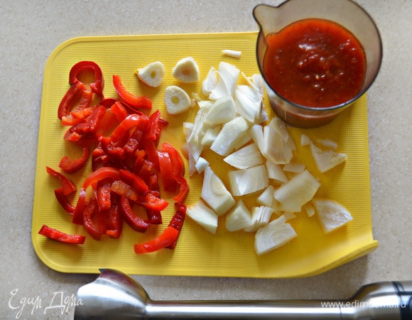 Тем временем приготовим соус. Для этого очищенный лук и чеснок нарежьте небольшими кусочками. Нарежьте перец. Если вы использовали, как и я, замороженный, разморозьте его. Свежего перца вам понадобится 1 шт. среднего размера. Все овощи вместе с мякотью баклажанов и томатным соусом (пассата или домашний, как у меня) сложите в чашу блендера, добавьте соль, сахар, лимонный сок, специи и измельчите до однородной массы.