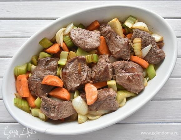 Все продукты нарезать средними кусочками. В сковороде разогреть оливковое масло. Говядину посолить, поперчить и обжарить на сильном огне до румяности со всех сторон. Переложить мясо в керамическую форму. На жире, оставшемся на сковороде, обжарить свиные колбаски, переложить их на блюдо. В той же сковороде обжарить овощную смесь (морковь, сельдерей, лук, чеснок). Овощи выложить к мясу.