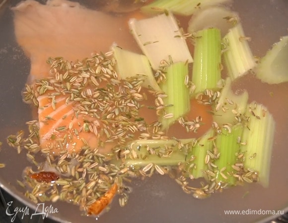 В большую тяжелую кастрюлю влить холодную воду, выложить панцири креветок, голову и ребра семги, морковь, сельдерей и раздавленный чеснок, добавить семена фенхеля и пеперончино и довести до кипения, затем снять пену, посолить и варить 30‒40 минут.