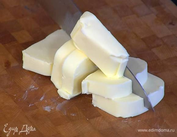 Предварительно охлажденное сливочное масло нарезать маленькими кубиками.