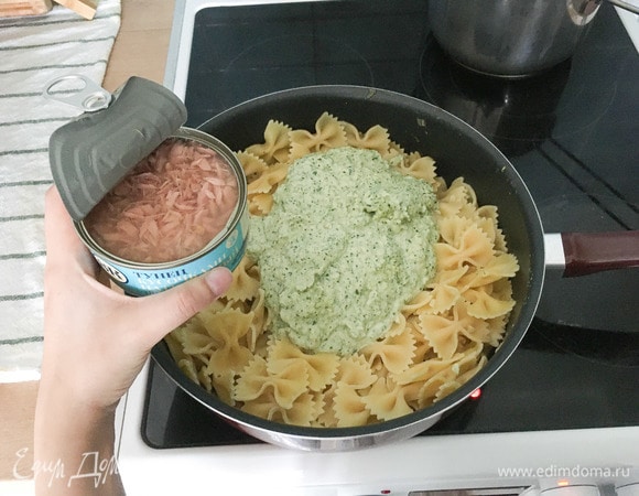 Отварить фарфалле в подсоленной воде, всыпать их в глубокий сотейник, добавить наш соус и тунца, посолить, перемешать.