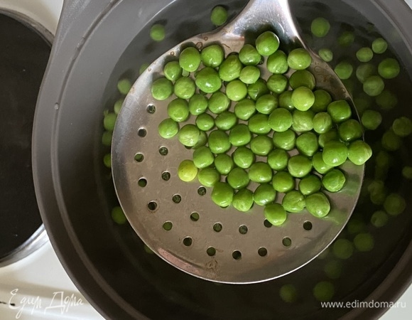Горошек разморозить. Влить в кастрюлю 1 литр воды, довести до кипения. Всыпать в воду горох, посолить и варить 2–3 минуты. Затем шумовкой достать горошек и залить ледяной водой. Это позволит гороху сохранить яркий цвет. В эту же воду положить лук, черешок сельдерея и морковь, нарезанные крупными кусками, добавить лавровый лист и перец горошком. Сварить овощной бульон, процедить и держать горячим на плите.