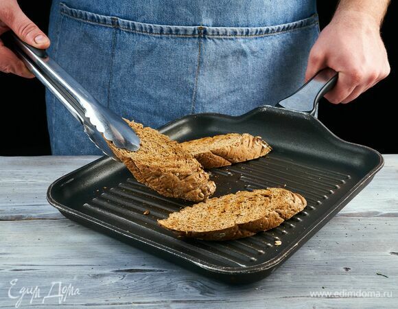 Багет разрежьте на порционные кусочки и подсушите на сковороде с обеих сторон.