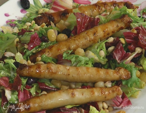 Салатный микс выложить на большую тарелку, посыпать изюмом и кедровыми орехами, сверху разложить колбаски.