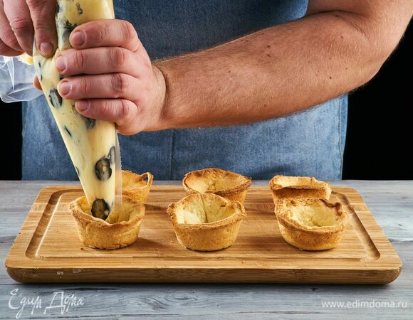 Тарталетки выпекайте в разогретой до 180°C духовке до румяного цвета около 20–30 минут. Готовые тарталетки остудите и освободите от формочек. На дно каждой тарталетки выложите крем.