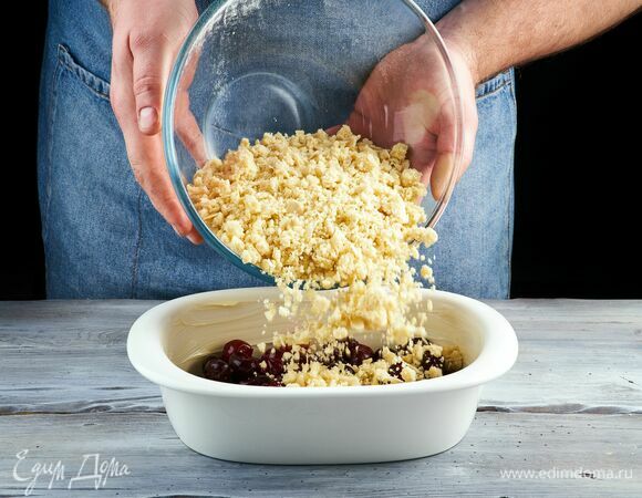 Подготовленную вишню выложите в форму, заполняя ее на две трети.<br />
Сверху на ягоды равномерно выложите слой крошки.