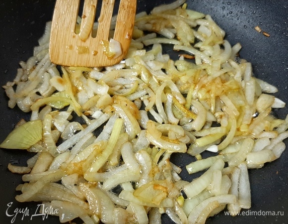 Нарезаем лук и обжариваем на сильном огне с добавлением небольшого количества растительного масла. Перекладываем в тарелку к грибам и бекону, сковороду оставляем.