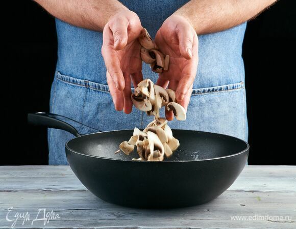 Выложите мелко нарезанный чеснок и жарьте 1 минуту, постоянно помешивая. Добавьте грибы к чесноку и обжаривайте до золотистого цвета.