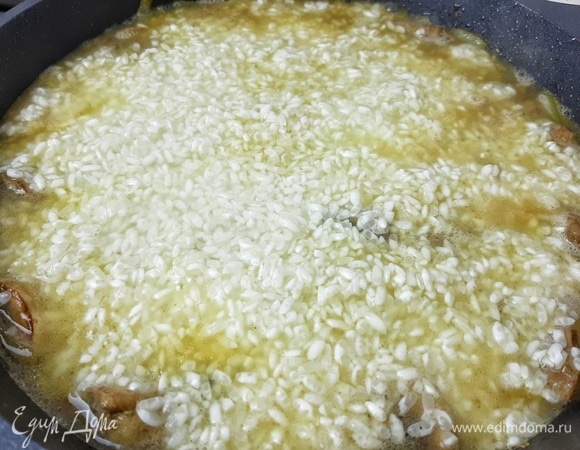 Выкладываем сверху рис для плова ТМ «Националь» и заливаем водой на 0.5 см выше уровня риса. Солим и перчим по вкусу. Готовим на медленном огне примерно 20 минут до полного испарения влаги. Затем убираем сковороду с огня и даем блюду отдохнуть еще минут 15.