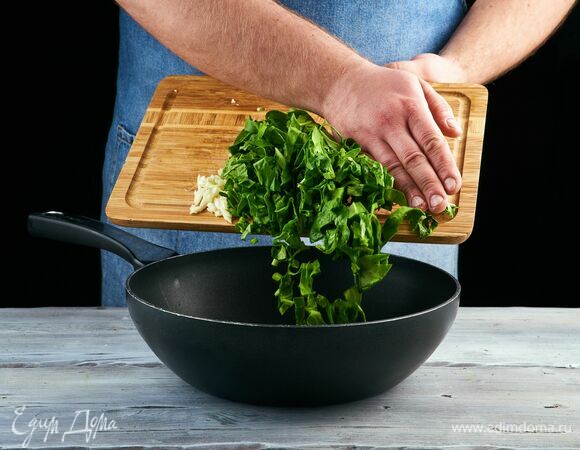 Разогрейте в сковороде 1 ст. л. оливкового масла, выложите шпинат и рубленый чеснок. Обжарьте, помешивая, на медленном огне.