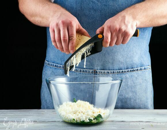 Натрите сыр на крупной терке и добавьте к творогу.