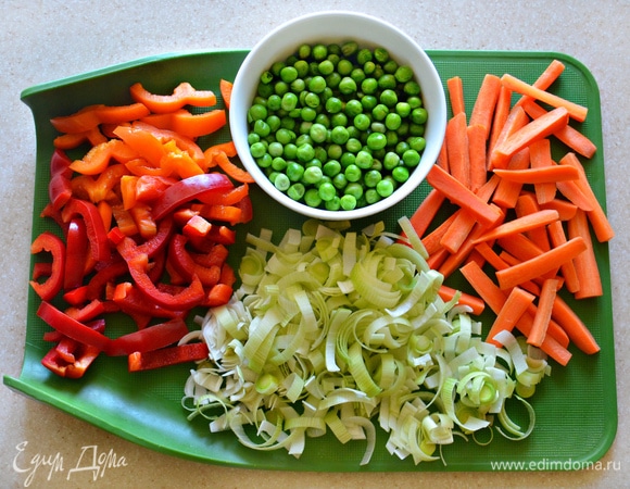 Зеленый горошек предварительно разморозьте. Морковь необходимо почистить и нарезать брусочками (небольшую морковь разрежьте вдоль на 4 части и затем нарежьте на куски по 3 см). Болгарский перец очистите от семян и плодоножки, нарежьте на небольшие полоски. Лук-порей (нам понадобится белая или светло-зеленая часть) промойте, разрежьте вдоль пополам и затем полукольцами.