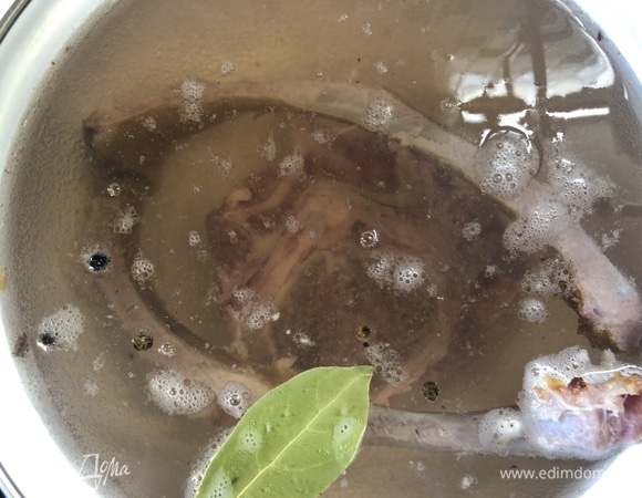 Залейте кости холодной водой, добавьте перец горошком и лавровый лист. Варите до готовности бульона, снимая пенку.
