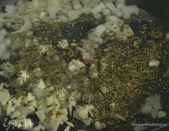 Чеснок почистить, мелко порубить и добавить в сковороду, затем всыпать итальянские травы, все перемешать.