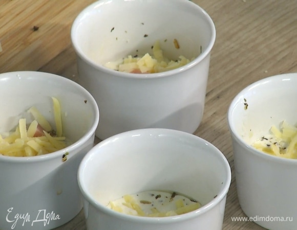 В четыре керамические формы для запекания разложить обжаренные грибы и влить сливки, так чтобы грибы были покрыты, сверху выложить ветчину и немного тертого сыра.