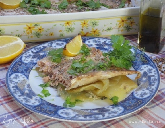 Достать блюдо из духовки, посыпать зеленью петрушки и подавать к столу, поливая рыбу соком печеного лимона.