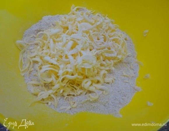 Добавить 1 ч. л. разрыхлителя, щепотку соли, сахар и ванильный сахар. Смешать. Затем добавить 130 г холодного натертого сливочного масла и руками перетереть в крошку.