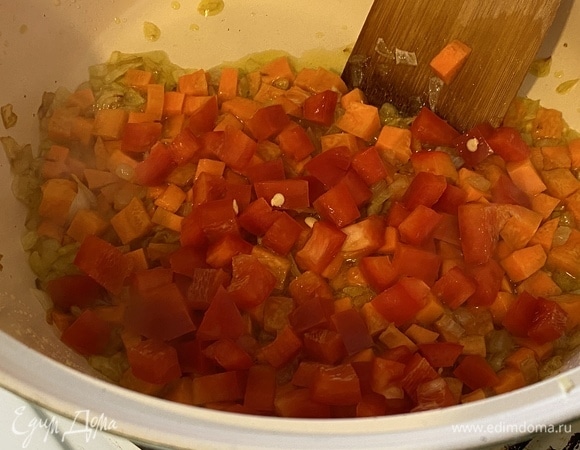 Через 3 минуты добавить болгарский перец, тоже нарезанный кубиком. Продолжать обжаривать овощи, постоянно помешивая.