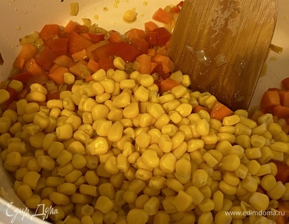 Засыпать консервированную кукурузу, предварительно слив с нее сок.