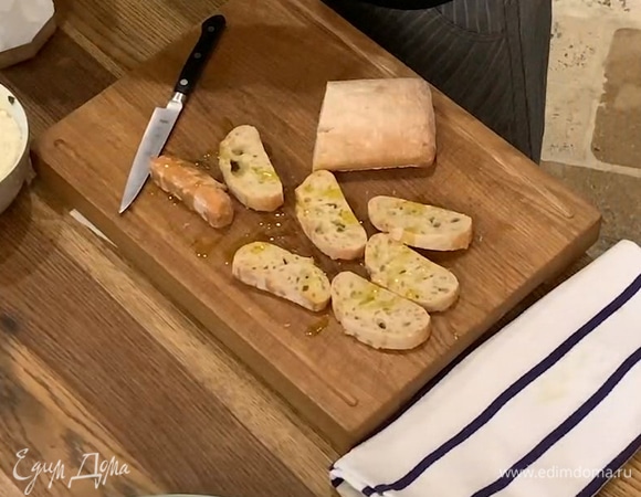 Хлеб нарезать ломтиками, сбрызнуть с двух сторон оставшимся оливковым маслом и обжарить на сухой сковороде-гриль.