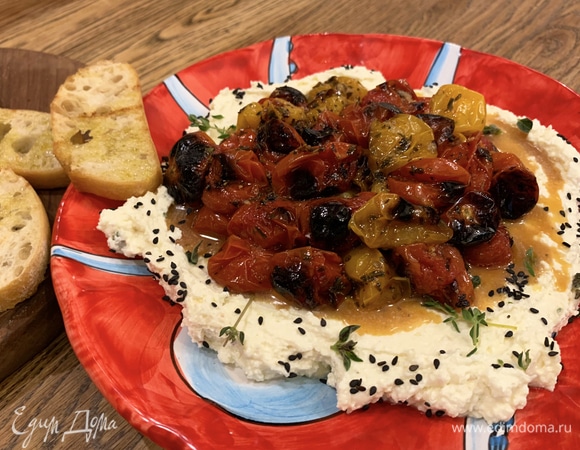 На большую тарелку выложить сырную смесь, посыпать оставшимся майораном, тимьяном и кунжутом, сверху разложить запеченные помидоры. Обжаренный хлеб подать на отдельной тарелке.