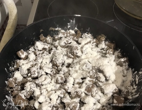 Засыпаем равномерно мукой, заливаем горячим говяжьим бульоном, тщательно перемешиваем и доводим до кипения.