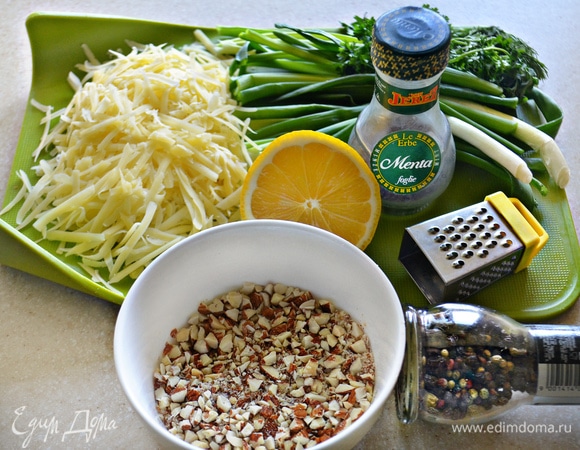 Сыр (любой твердый на ваш вкус) натрите на терке, 1/3 отложите для посыпки запеканки. Миндаль измельчите в мелкую крошку, зеленый лук и петрушку нарежьте, натрите мелко цедру половины лимона.