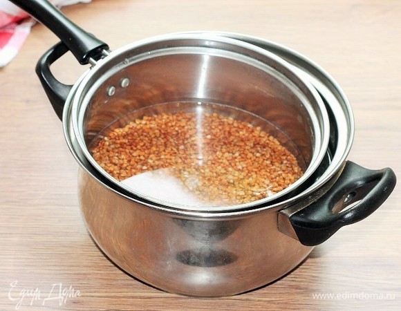 Залейте чистой водой (1,5 стакана) и посолите. Поставьте ковшик с гречкой на кастрюлю с кипящей на медленном огне водой.