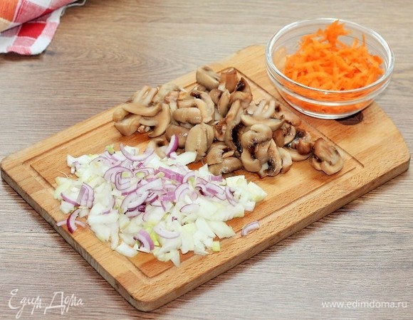 Приготовим соус. Шампиньоны, лук и морковь очищаем. Грибы нарезаем пластинами, лук — кубиками, морковь трем на крупной терке.