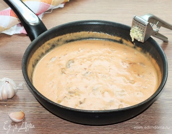 Влейте мучную смесь в сковороду с грибами. Добавьте прессованный чеснок и, периодически перемешивая, доведите соус до кипения. Варите на слабом огне до небольшого загустения (консистенция, как тесто на блины).