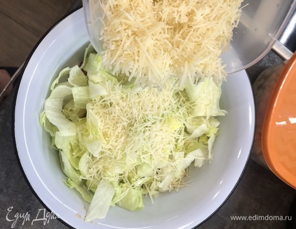 Добавляем почти весь пармезан и оставляем чуть-чуть для декора. Далее выливаем соус в салат и перемешиваем. Руками намного удобнее. Выкладываем салат по тарелкам, посыпаем сухариками и оставшимся пармезаном. Можно использовать слайсы сыра для украшения.