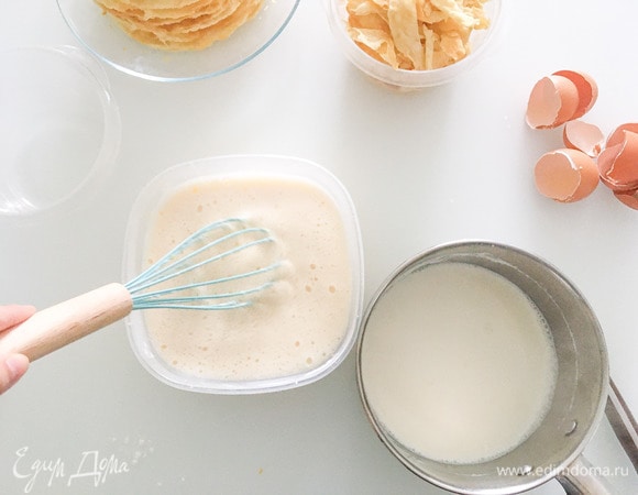 Помешивая, влить горячее молоко в яичную смесь.