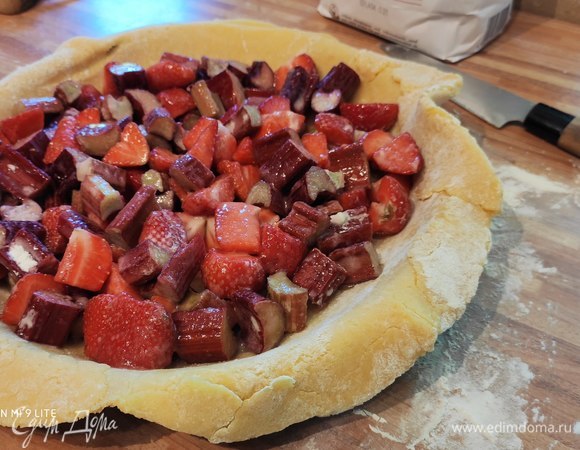 Тесто раскатать на пергаментной бумаге или, как я, на припыленной мукой поверхности. Я использовала смазанную маслом и посыпанную мукой форму для тарта и перенесла тесто в форму. Тесто должно быть в диаметре больше вашей формы на несколько сантиметров. Выложить начинку, оставив края свободными.