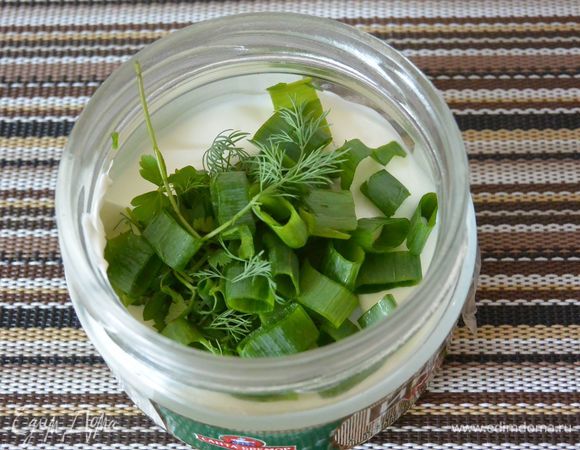 В сметану положим много нарезанной зелени лук, петрушку и укроп. Смазываем рыбу смесью из сметаны и зелени. Кладем рыбу в форму для запекания, накрываем фольгой и отправляем в духовку на 30 минут.