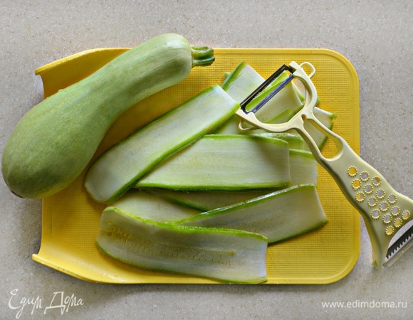 Молодой кабачок (или цукини) нарежьте вдоль с помощью овощечистки тонкими слайсами.