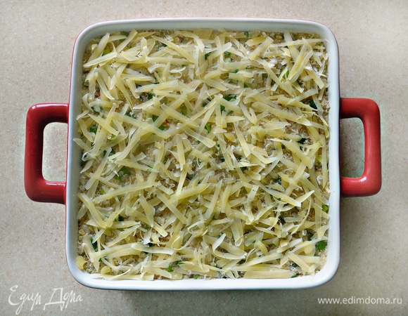 Посыпьте сверху оставшимся сыром. Готовьте запеканку в разогретой до 180°C духовке около 45 мин. За несколько минут до конца приготовления посыпьте запеканку миндальными лепестками.