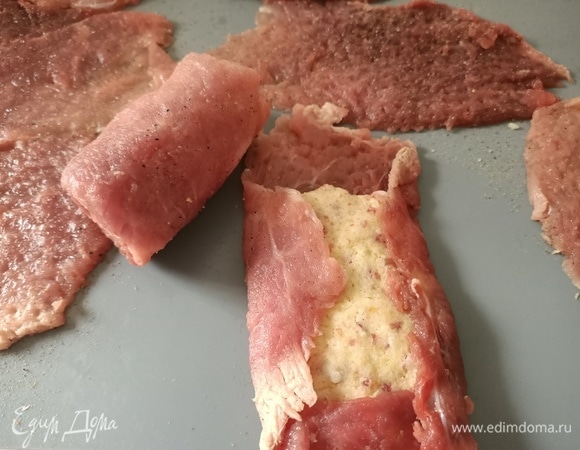 Начинку выложить на мясо, сформировать рулетики.