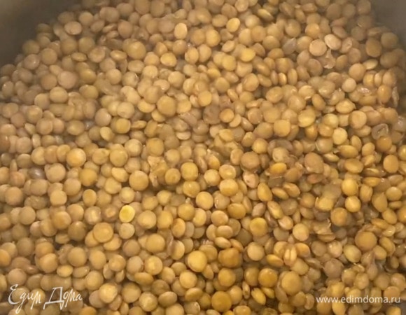 Чечевицу отварить согласно инструкции на упаковке, затем выложить в тарелку и полить половиной заправки.