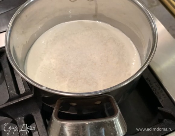 Молоко и сливки влить в кастрюлю, всыпать 2 горсти кокосовой стружки и довести все до кипения.